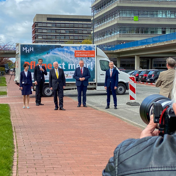 Gruppenbild: Martina Saurin, Andreas Fischer, Michael Manns, Frank Lammert und Björn Thümler vor einem Plakat der MHH-Pflegekampagne.