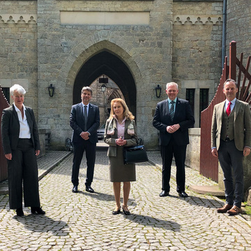 Gruppenbild im Innenhof der Marienburg: Nicolaus von Schöning, Schloss Marienburg GmbH & Co. KG, Kulturminister Björn Thümler, Dr. Alexandra Wenck, Stiftung Schloss Marienburg, HAWK-Präsident Dr. Marc Hudy, NLMH-Direktorin Prof. Dr. Katja Lembke.