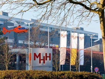 Ein Rettungshubschrauber fliegt vor dem Eingang der MHH.