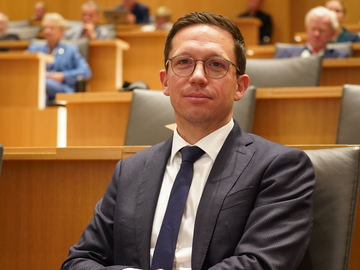 Niedersachsens Wissenschaftsminister Falko Mohrs sitzt beim "Bridges of Knowledge"-Event im Veranstaltungssaal des Schlosses Herrenhausen