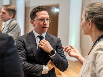 Minister Falko Mohrs unterhält sich mit einer Frau bei der Konferenz "Preventive Health Care: From Research to Action"