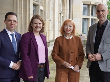 Ein Gruppenbild vor einer steinernen Fassade mit Wissenschaftsminister Falko Mohrs, Kultusministerin Julia Willie Hamburg, Heidelinde Gerhold (Vorstandsvorsitzende der GETEC Stiftung), Oberbürgermeister Belit Onay.