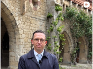Ministers Mohrs schaut in die Kamera. Er steht in einem Regenmantel vor dem Schloss Marienburg.