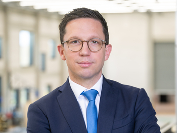 Ein klassisches Porträtbild von Minister Mohrs mit verschränkten Armen vor der Brust