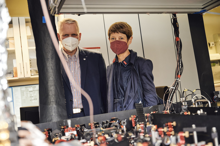 Minister Björn Thümler und Angela Ittel, Präsidentin der TU Braunschweig, stehen nebeneinander und betrachten Quantentechnologie.