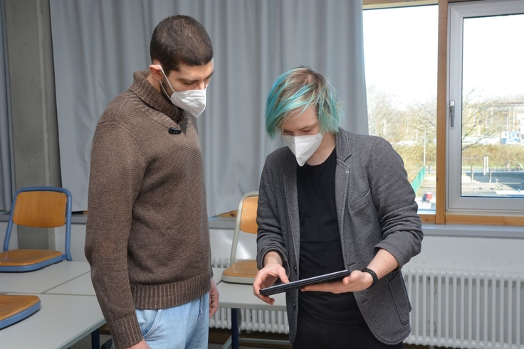 Zwei Studenten blicken auf ein Tablet