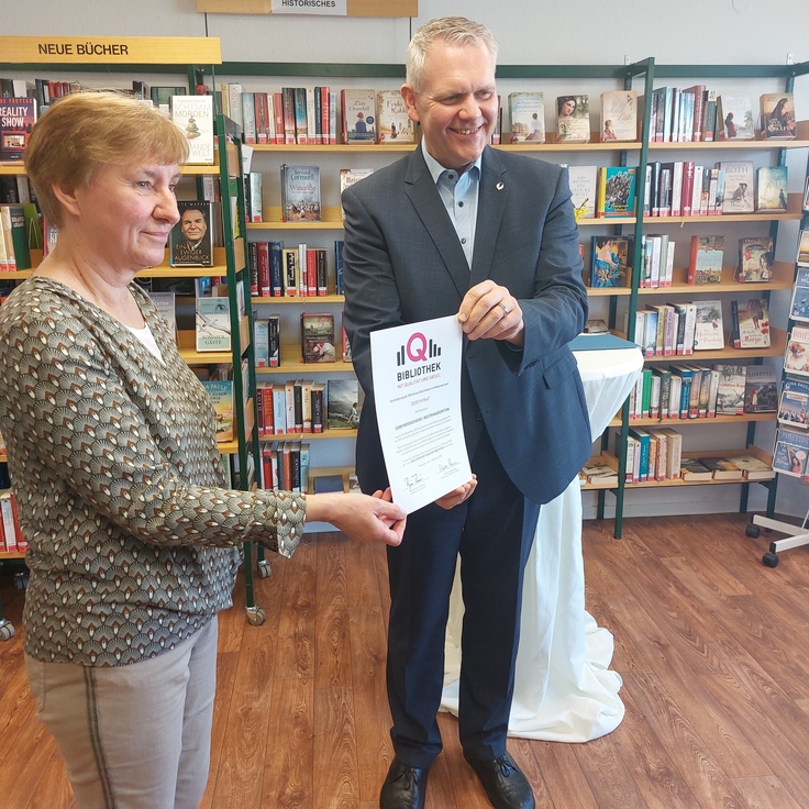 Minister Björn Thümler übergibt der Gemeindebücherei Westrhauderfehn die Urkunde für „Bibliothek mit Qualität und Siegel“.