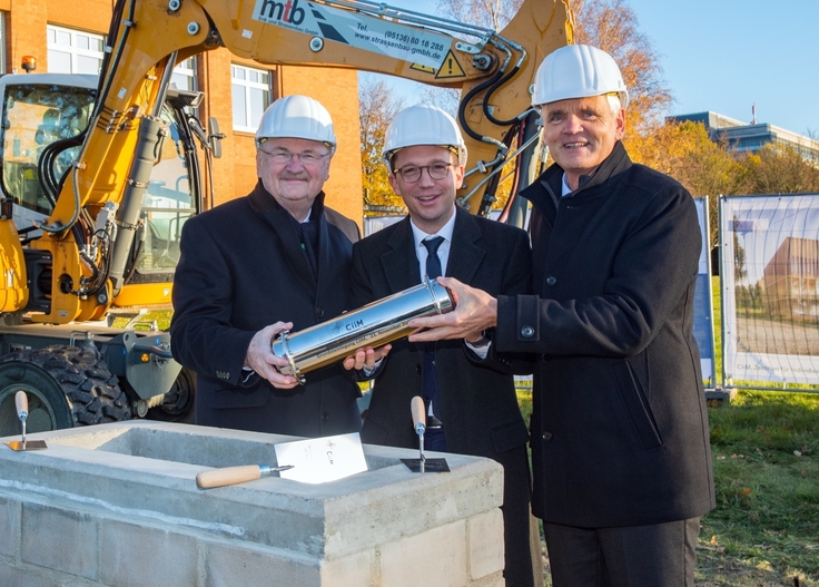 Minister Falko Mohrs, MHH-Präsident Professor Dr. Michael Manns und HZI-Geschäftsführer Dr. Dirk Heinz mauern eine silberne Zeitkapsel in den Grundstein ein.