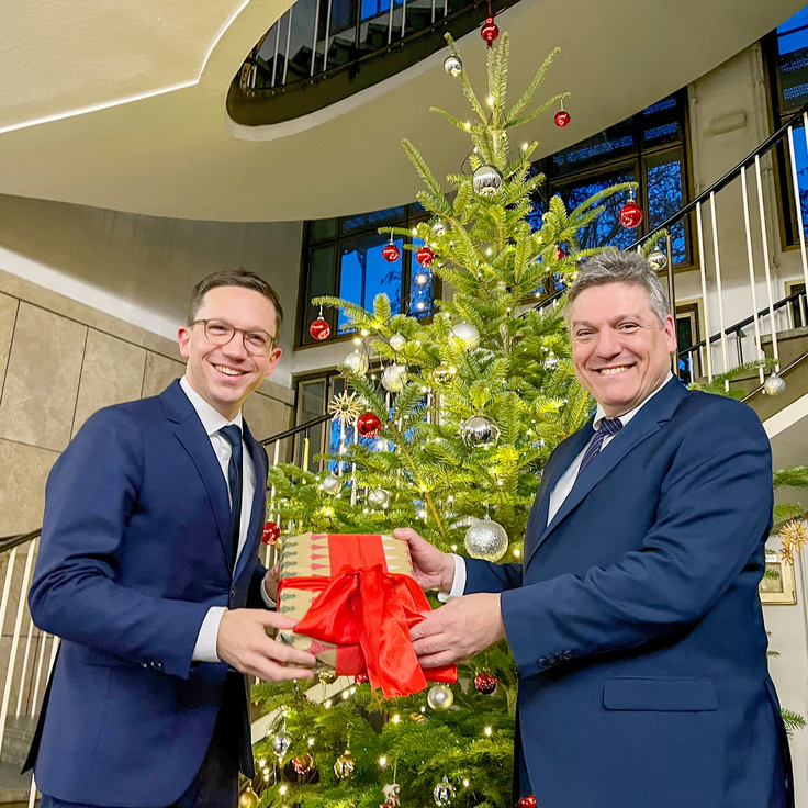 Minister Falko Mohrs und Staatssektretär Joachim Schachnter vor einem Weihnachtsbaum im MWK,