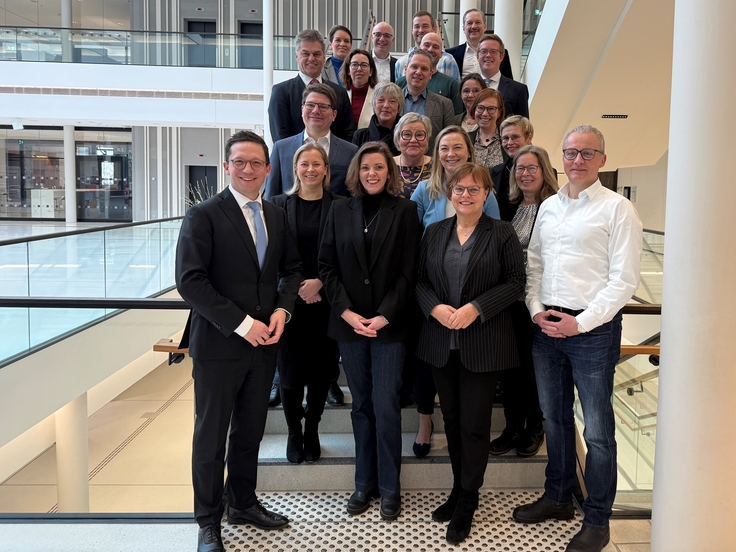 Minister Falko Mohrs steht mit dem Fachkuratorium der Landeszentrale für politische Bildung im Landtag