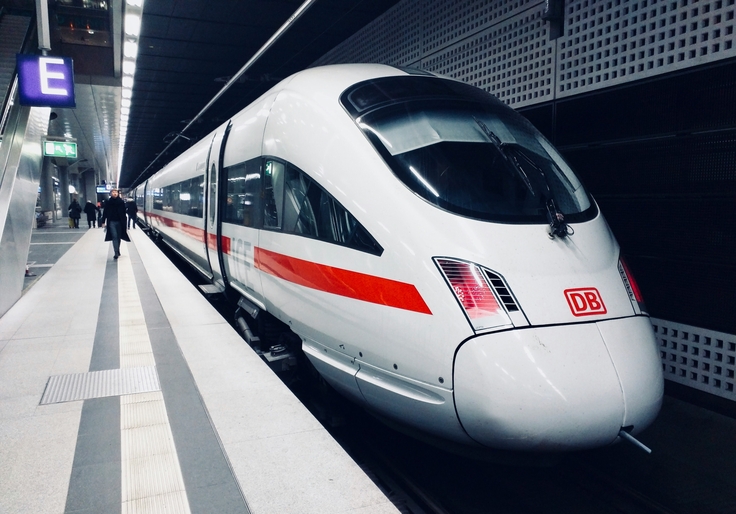 Ein ICE steht in einem hell erleuchteten Bahnhof.