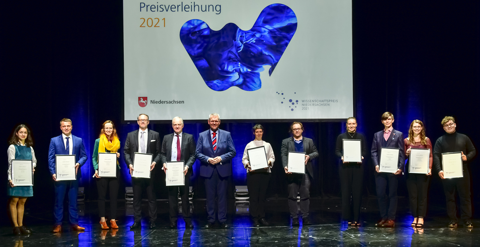 Gruppenfoto der Preisträgerinnen und Preisträger des Wissenschaftspreises Niedersachsen 2021 mit Minister Björn Thümler auf der Bühne im Schauspielhaus Hannover.
