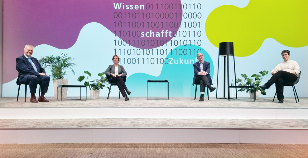 Schmuckbild: Vier Personen sitzen auf einer Bühne. Von links: Minister Bjrön Thümler, Christine Falk, Tobias Welte, Viola Priesemann.
