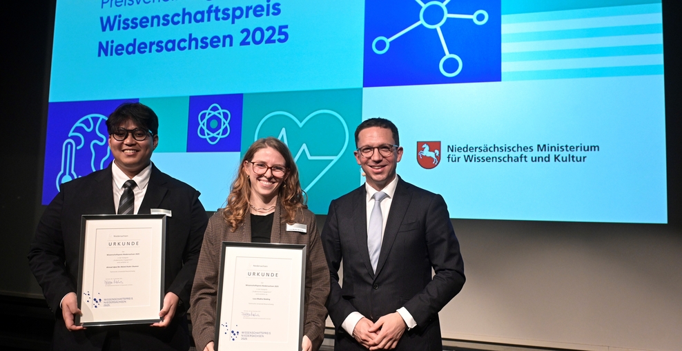 Zwei Studierende werden von Wissenschaftsminister Falko Mohrs geehrt.