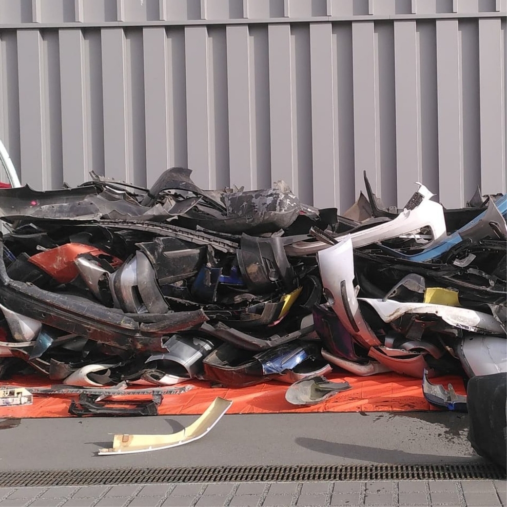 Das Foto zeigt einen grauen Hof, in dem einige Stoßstangen liegen, die für das Projekt verwendet werden.