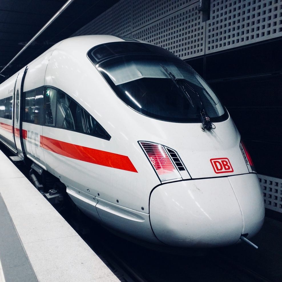 Ein ICE steht in einem hell erleuchteten Bahnhof.