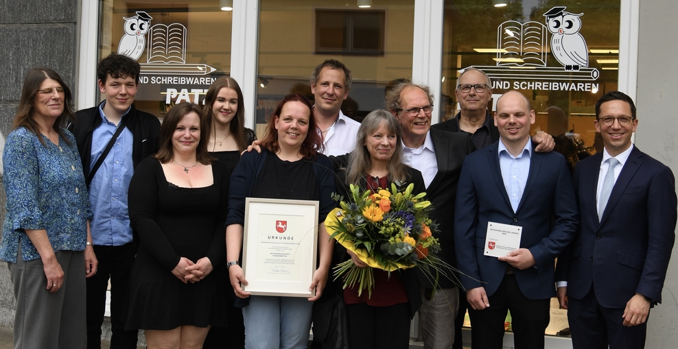 Die Mitarbeitenden der Buchhandlung Patz feiern gemeinsam mit Minister Mohrs den Buchhandelspreis 2026