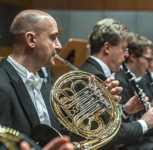 Orchester-Musiker, im Vordergrund ein Hornist, im Hintergrund ein Klarinettist